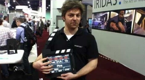 A man holding up a clapper board at a convention.