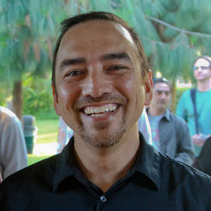 Man smiling at an outdoor event.