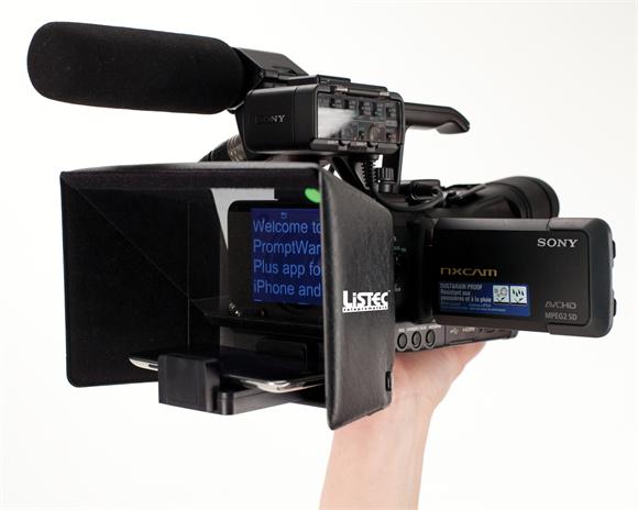 A person holding a video camera with a microphone attached to it.