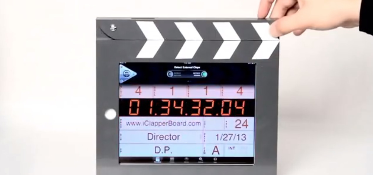 A digital movie slate displaying timecode and production details with a hand lifting the top part.