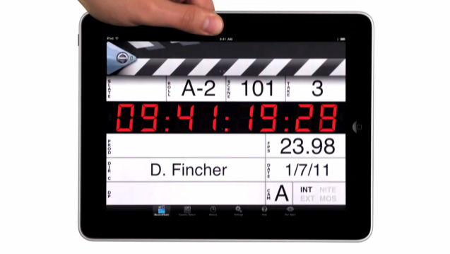 A hand holding a MovieSlate clapperboard displayed on an iPad screen.