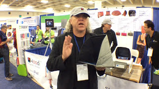 Man gesturing while holding the Hoodini iPad Shade at a trade show booth.