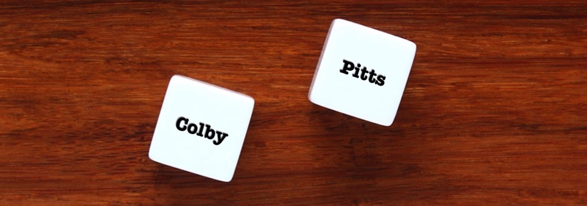 Two Name Dice with random character names "colby" and "pitus" on a wooden surface.