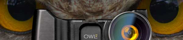 Close-up of a camera lens with a reflection of an owl's face, featuring the coolest camera grip.