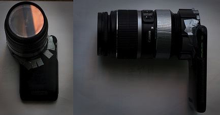 A camera with a 35mm lens attached, and duct tape on its battery compartment indicating a makeshift repair.