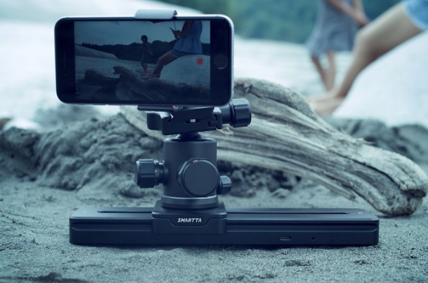 Smartphone mounted on an ultra-portable gimbal capturing two people on a beach, perfect for mobile filmmakers.