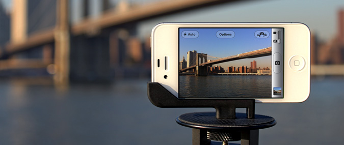 Smartphone mounted on a GLIF tripod mount capturing a photo of a bridge.